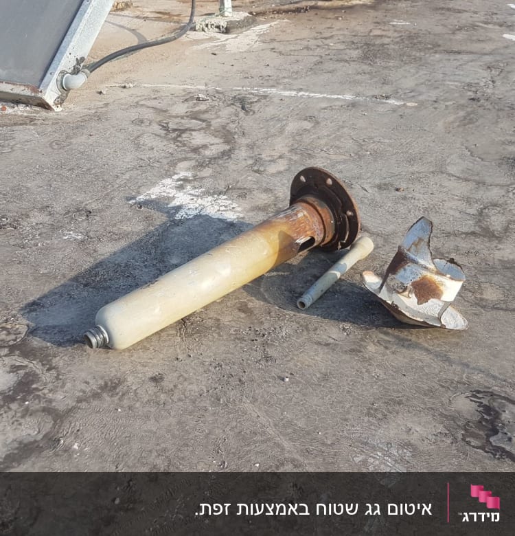 חלקי מתכת וצינור על גג בטון